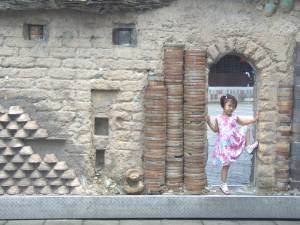 A child poses in a doorway that is part of an installation of street art. photo: A. Singer
